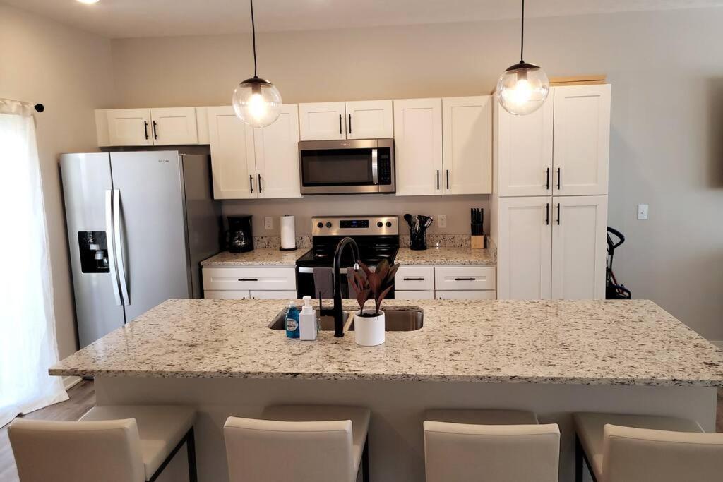 a kitchen with white cabinets and a granite counter top at The Prairie at Coventry Rows in Omaha