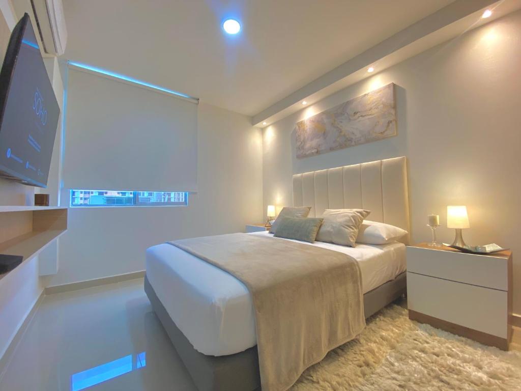 1 dormitorio con 1 cama grande y TV en Apartamentos Mirador - Excelente Ubicacion by SOHO, en Barranquilla