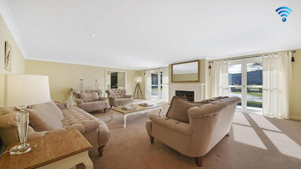 a large living room with couches and a fireplace at Camelot in Bowral
