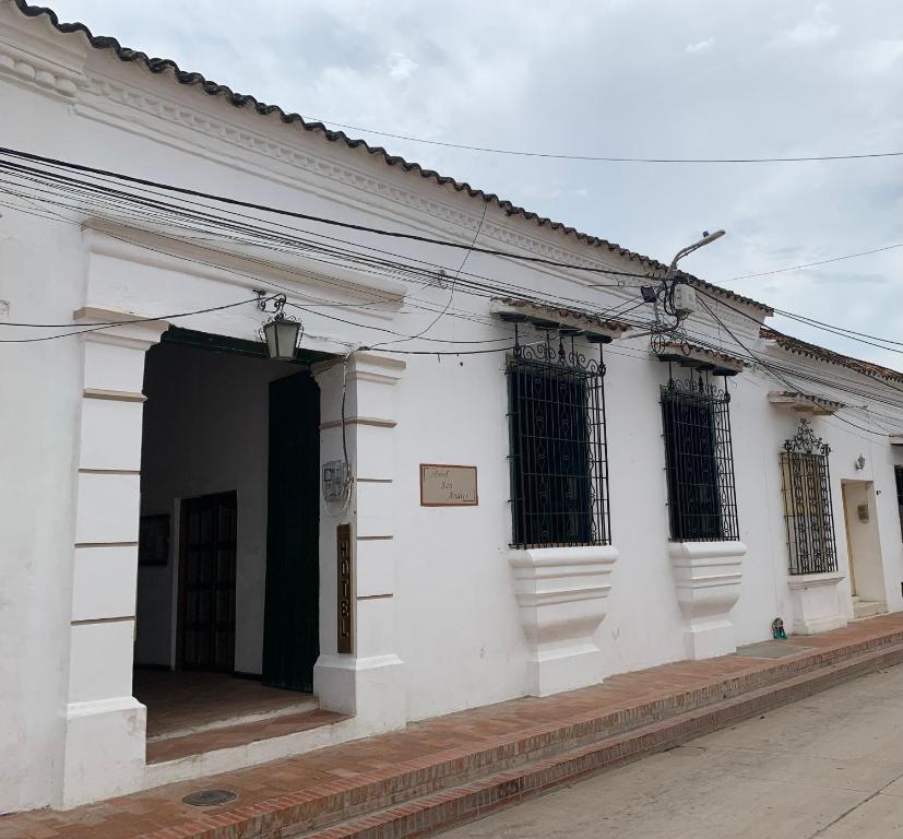 un edificio blanco con una puerta y ventanas negras en Hotel San Andres Mompox, en Mompox