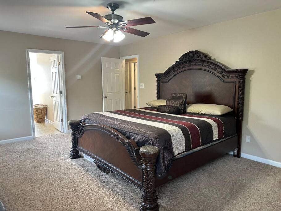 a bedroom with a large bed with a ceiling fan at Grand Lux Getaway in Lexington