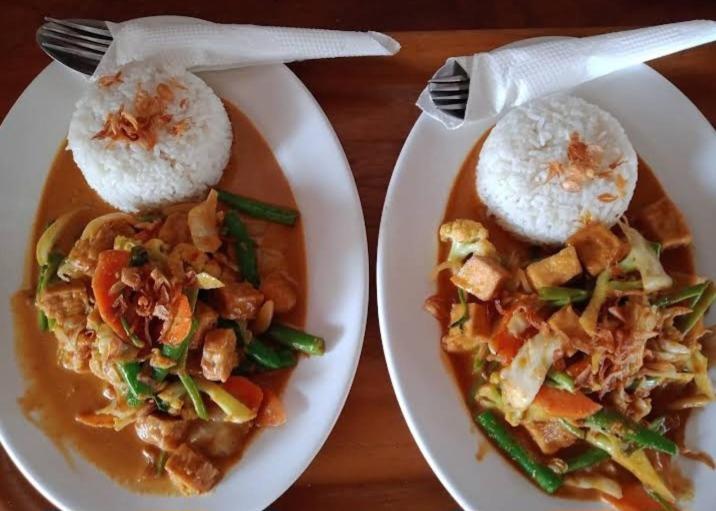 zwei Teller mit Reis auf dem Tisch in der Unterkunft Whynot Bar and Bungalows #01 in Pawenang