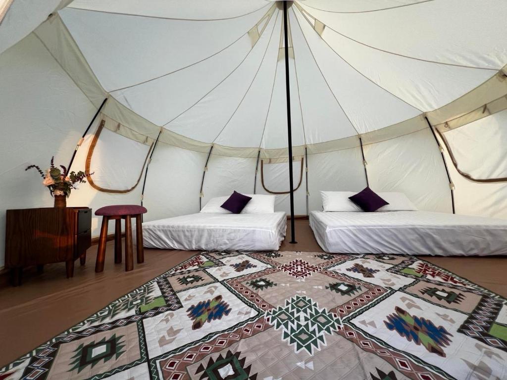 a tent with two beds and a rug in a room at La Fleur Glamping in Minrong Sekang