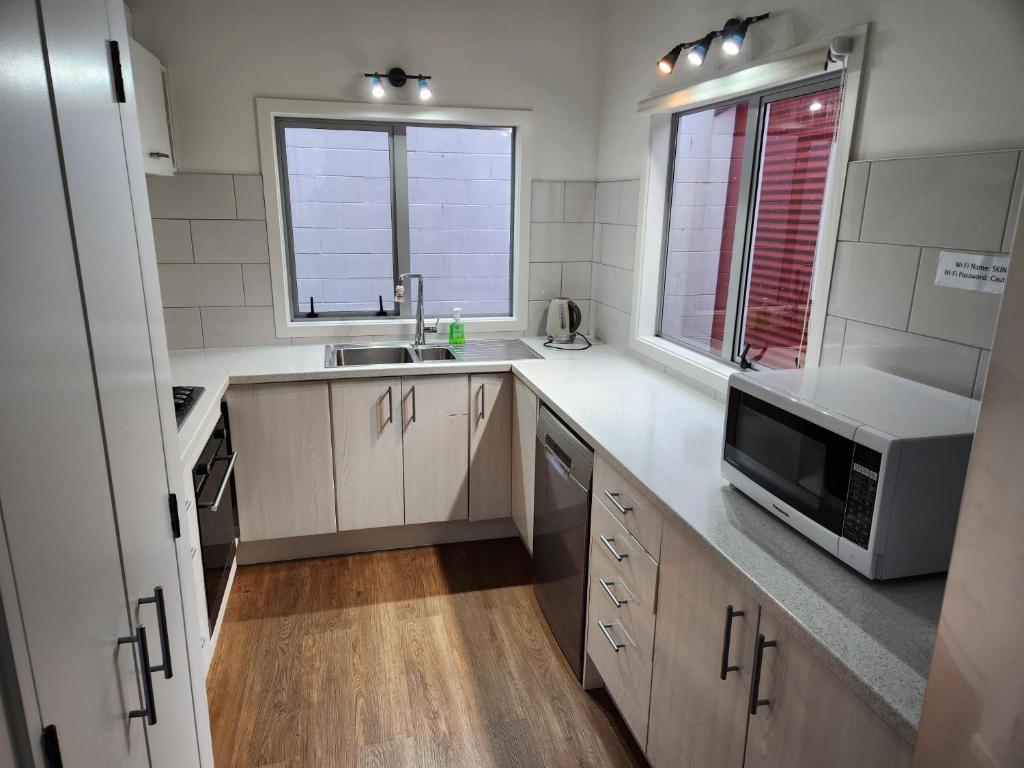 a kitchen with a sink and a microwave at An inner city 4-bedroom house with two carparks in Wellington