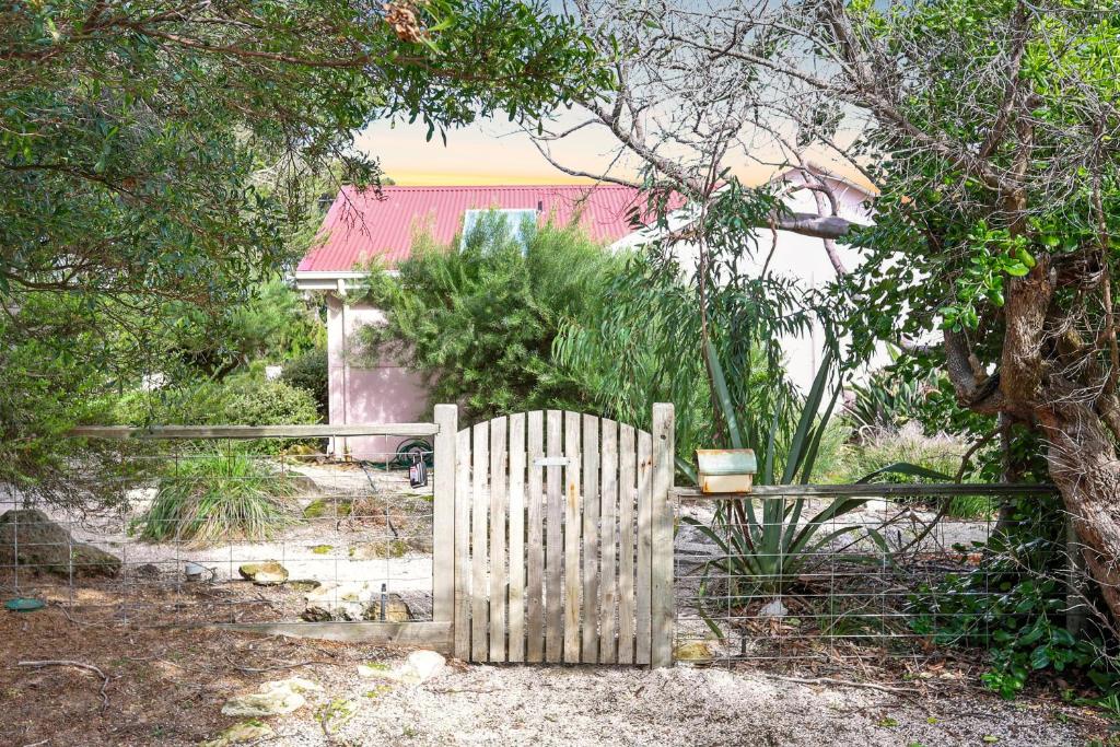 um portão de madeira num quintal com uma cerca em Pink Cabin By Host on the Coast em Barwon Heads