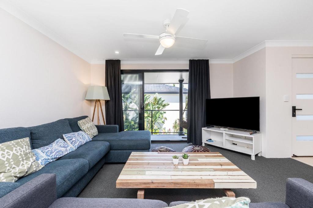 a living room with a blue couch and a tv at Byron Bay Accom Unit 3 5-9 Somerset Street - Summer Central in Byron Bay