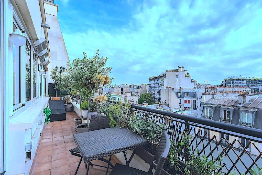 un balcon avec un banc et une vue sur une ville dans l'établissement Appart Terrasse Vue Tour Eiffel, à Paris