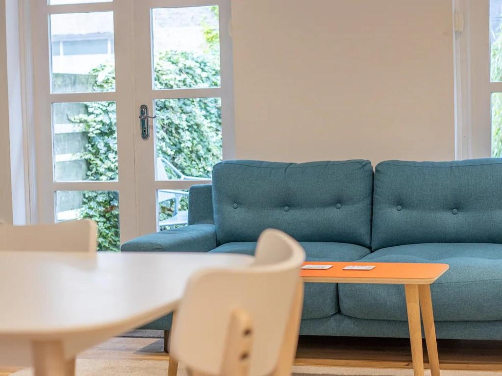 un sofá azul en una sala de estar con mesa y sillas en Pass the Keys Stylish West End Detached Mews en Glasgow