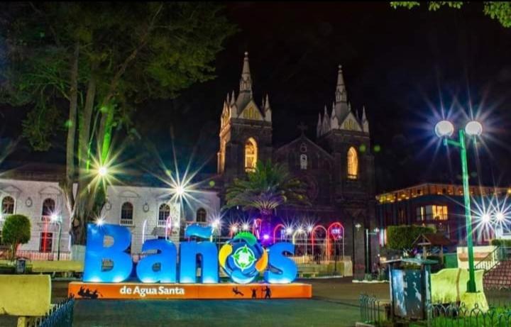 un edificio con un cartel delante de él por la noche en CASA VACACIONAL NACHO, en Baños