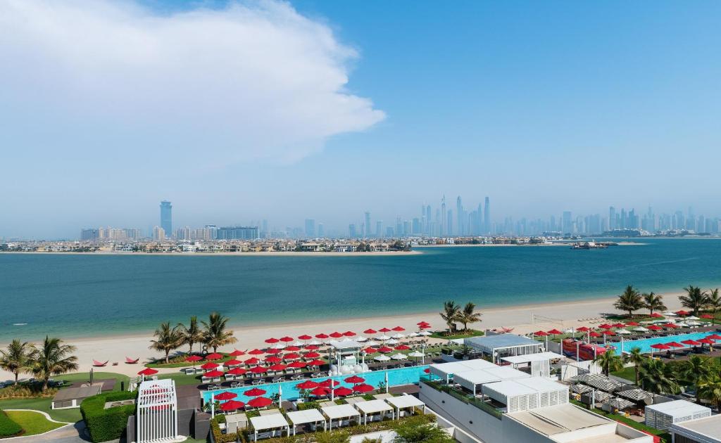 杜拜的住宿－Th8 Palm Dubai Beach Resort Vignette Collection, an IHG hotel，海滩空中美景,配有遮阳伞