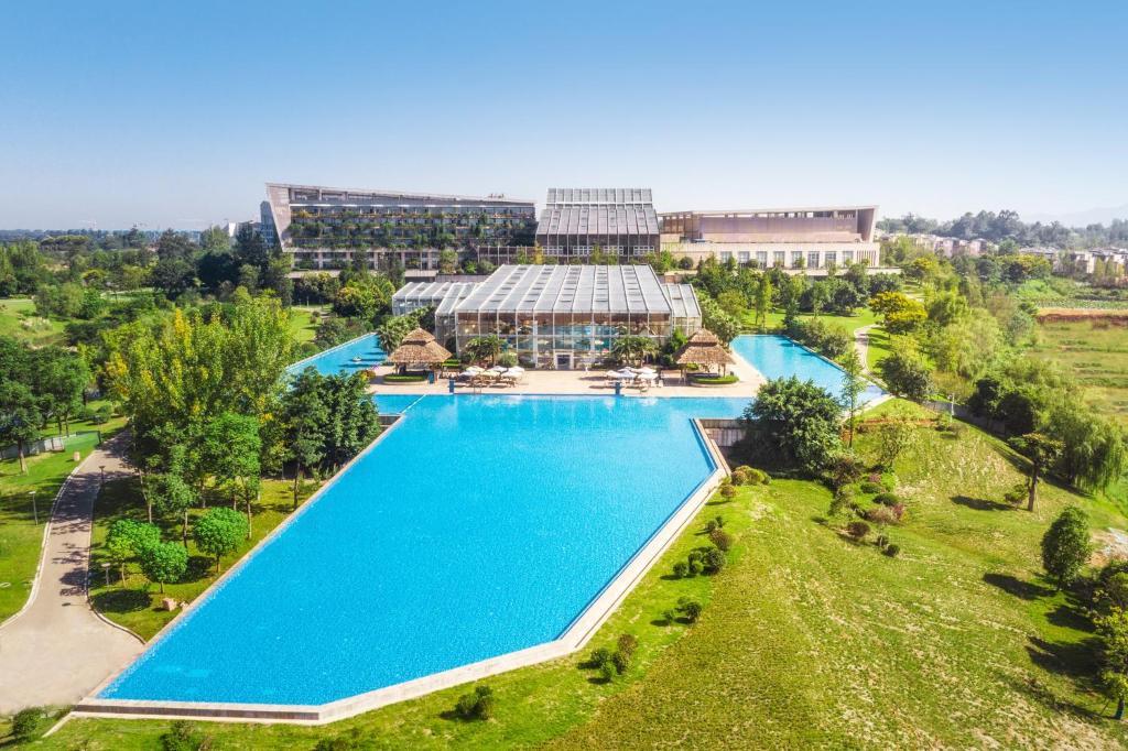 una vista aérea de una gran piscina frente a un edificio en InterContinental Heilong Lake, an IHG Hotel, en Meishan