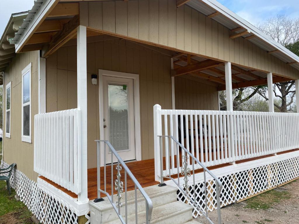 a small house with a porch and a white railing at Rio grand country getaway in Harlingen