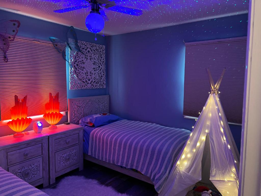 Un dormitorio púrpura con una cama con luces. en Villa Vesta, en Michigan City