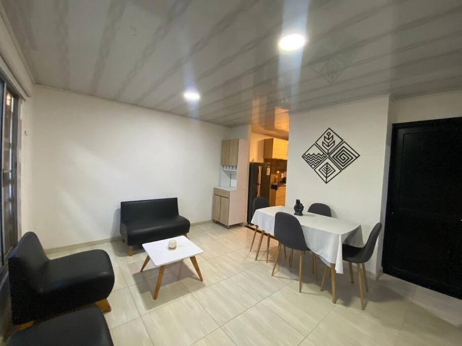 een woonkamer met een tafel en stoelen en een keuken bij Cómoda casa cerca al centro in San José del Guaviare