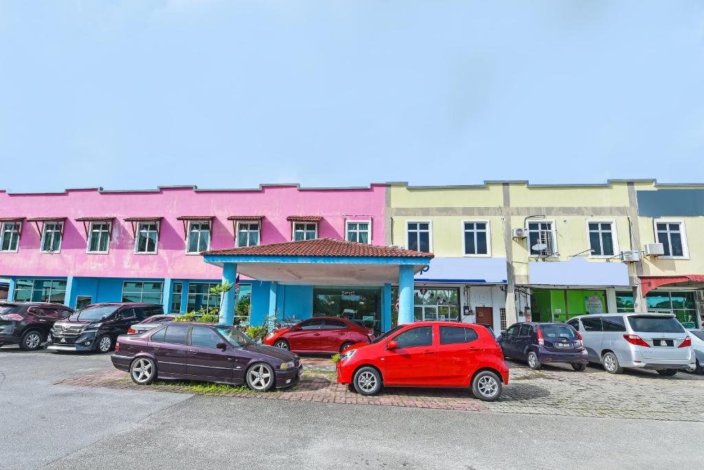 grupa samochodów zaparkowanych na parkingu w obiekcie OYO 275 Senyum Inn w mieście Pantai Cenang