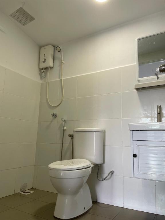 uma casa de banho com um WC e um chuveiro em Casa Lena em Cherating