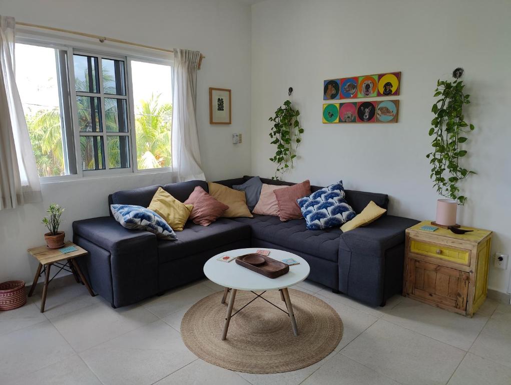 - un salon avec un canapé bleu et une table dans l'établissement Casa Coloradita/Cozy colorful flat with Starlink, à Holbox