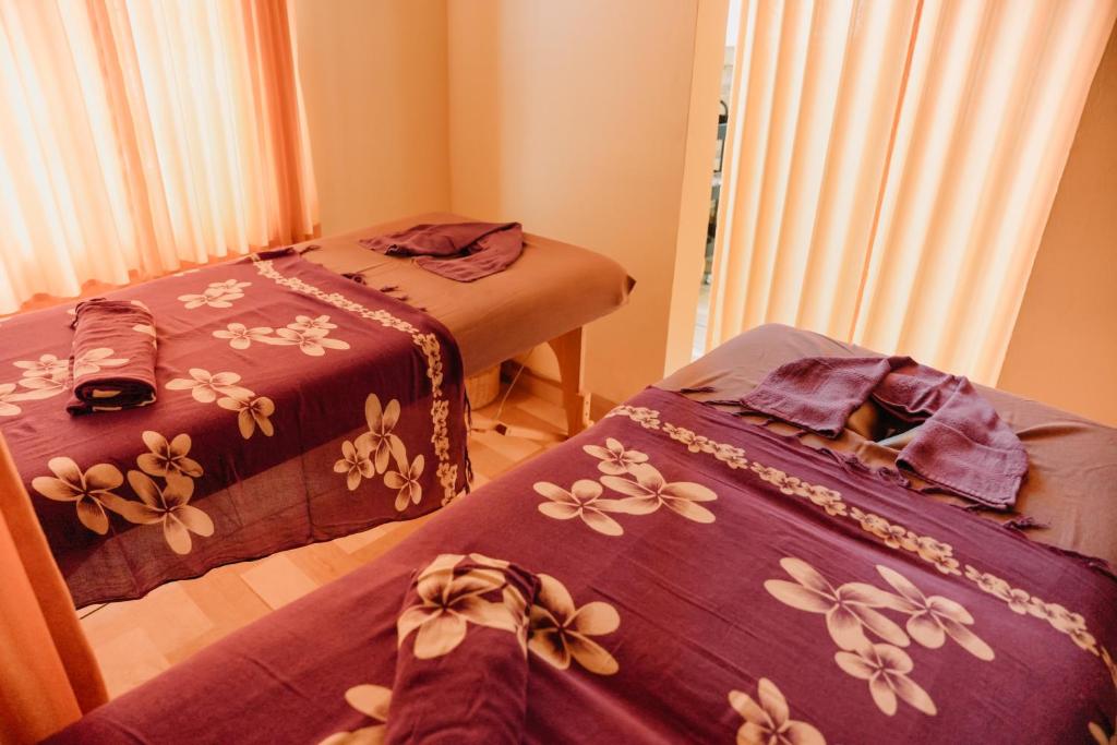 a room with two beds with flowers on them at Taman Asih Bingin Homestay in Uluwatu