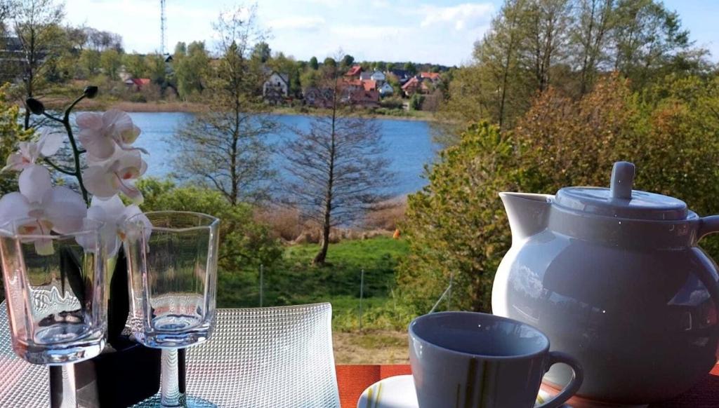 una mesa con un jarrón y dos vasos y una taza en Domus Mare Tiny House 1 en Wisełka
