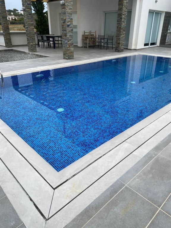 a large swimming pool with blue water in a building at The Anemoni 5 Villa in Protaras