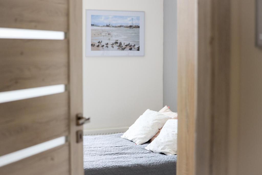 een slaapkamer met een bed met 2 kussens erop bij Apartament Kapitański in Pogórze