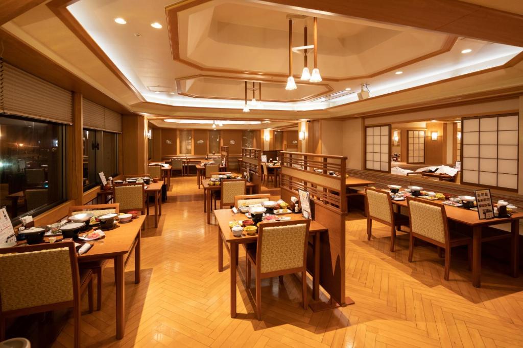 um restaurante com mesas e cadeiras num quarto em Bankokuya em Tsuruoka