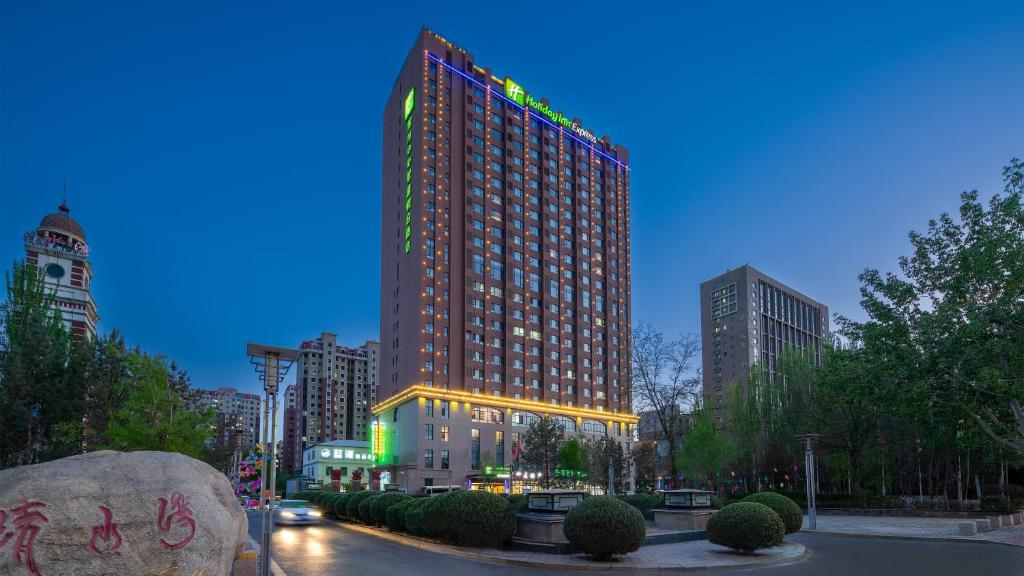 ein hohes Gebäude mit Lichtern in einer Stadt in der Unterkunft Holiday Inn Express Yinchuan Downtown, an IHG Hotel in Yinchuan