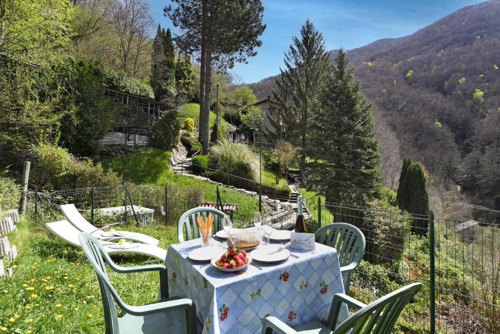 una mesa con un mantel blanco y sillas en una colina en Casa Lara - Happy Rentals, en Lugano