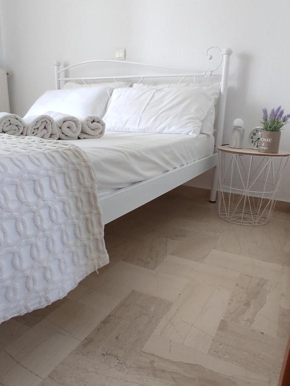a white bed with white sheets and pillows on it at Νέος Πύργος Studio in Neos Pirgos