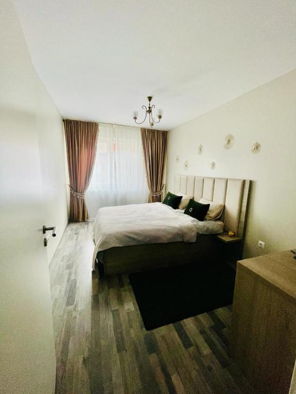 a bedroom with a bed and a chandelier at Home Sweet Home in Braşov