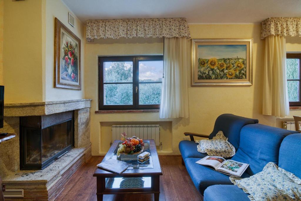 un salon avec un canapé bleu et une cheminée dans l'établissement Tenuta Di Litiano With Pool - Happy Rentals, à Roccastrada