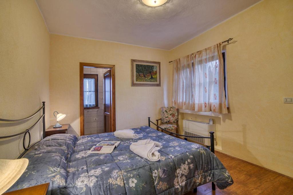 une chambre avec un lit avec une couette bleue dans l'établissement Tenuta Di Litiano With Pool - Happy Rentals, à Roccastrada