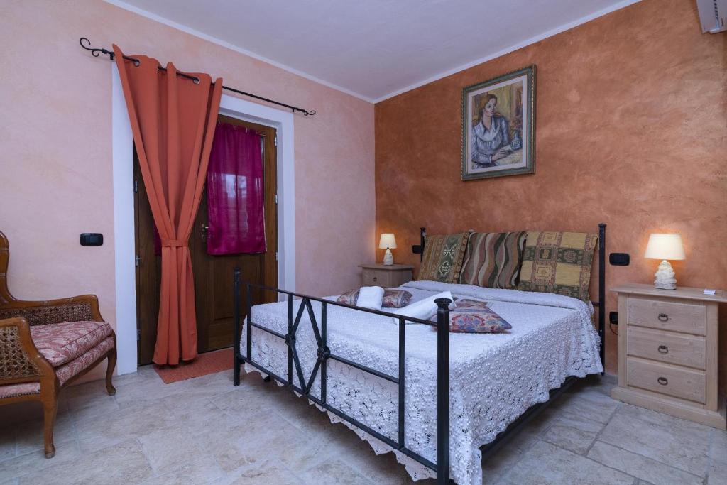 une chambre avec un lit, une chaise et une fenêtre dans l'établissement Tenuta Di Litiano With Pool - Happy Rentals, à Roccastrada