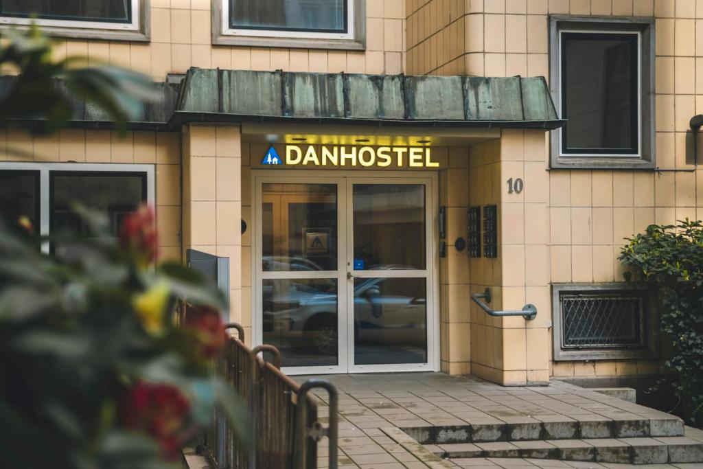 un cartel en la parte delantera de un edificio con una puerta de cristal en Danhostel Aarhus City en Aarhus