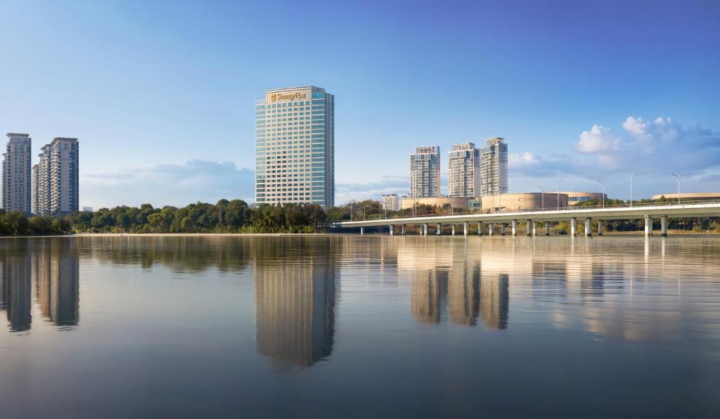 揚州的住宿－揚州香格里拉酒店，一座拥有高楼和湖上桥梁的城市