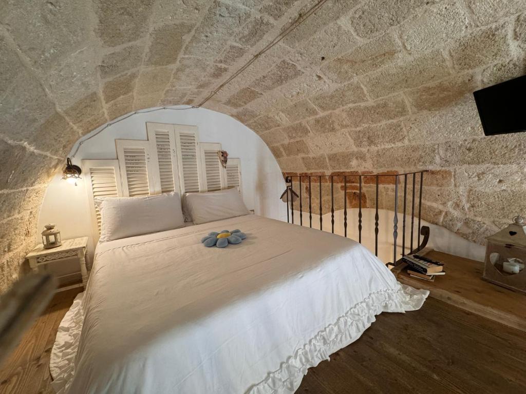 a bedroom with a white bed with blue flowers on it at B&B Casa Fiore in Polignano a Mare