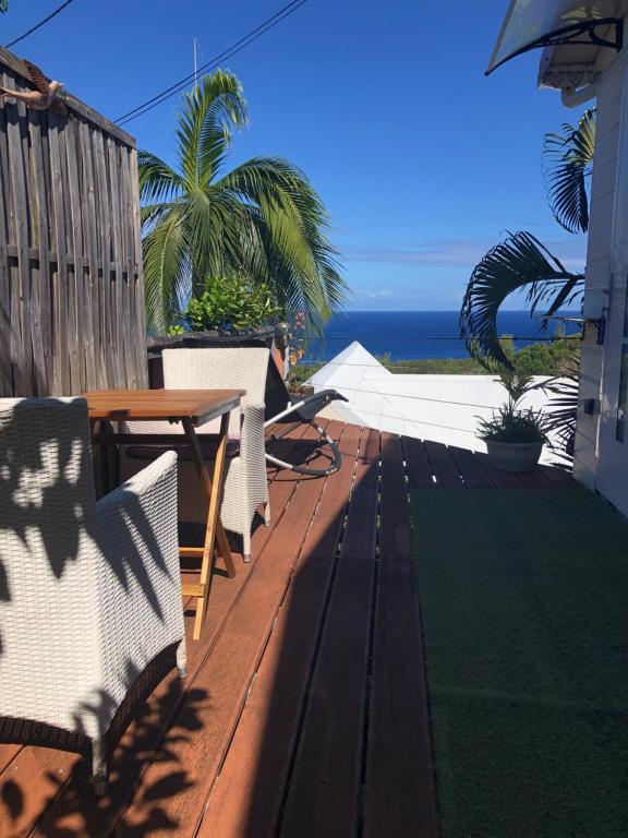 un patio con tavolo, sedie e vista sull'oceano di Manapany ti coin charmant a Saint-Joseph