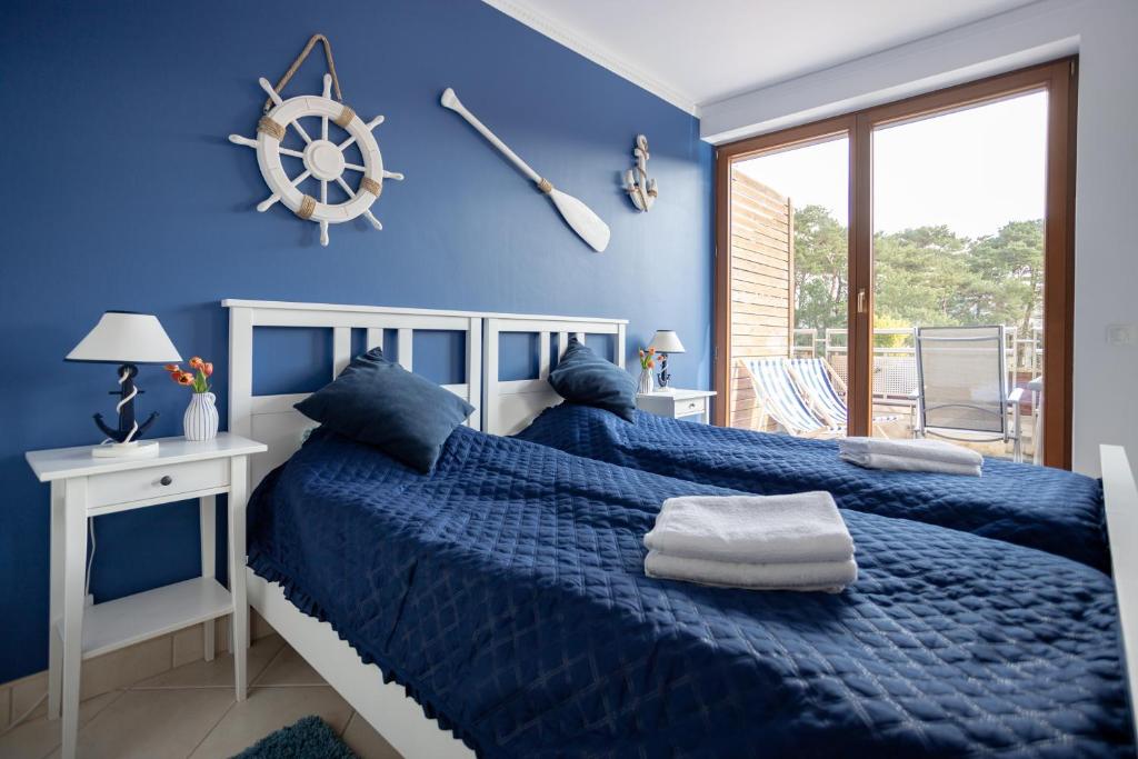 a blue bedroom with a bed with a blue comforter at Międzymorze 1024 in Jurata