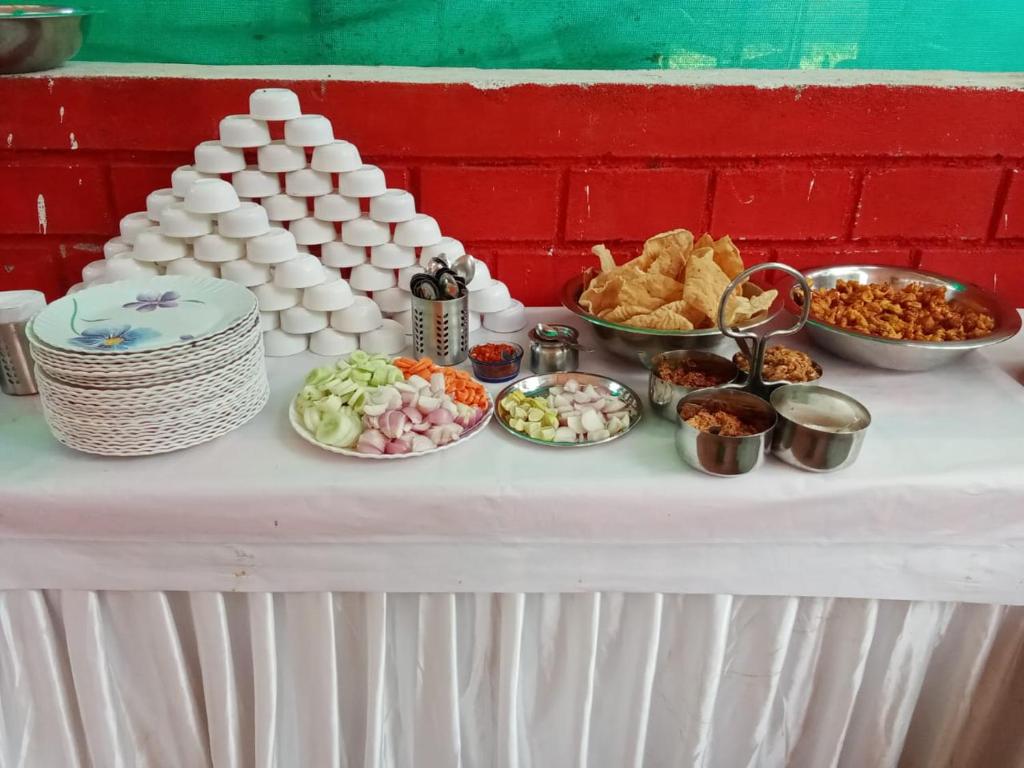 una mesa cubierta con platos de comida en una mesa en Mahuli Agro Tourism, en Mansar