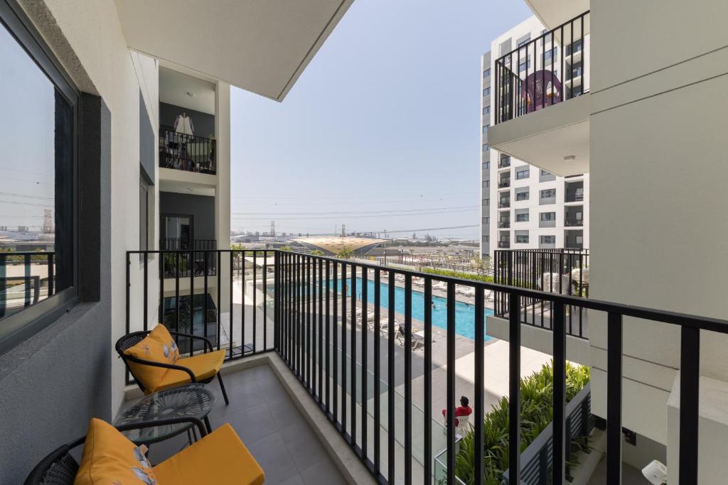 een balkon met uitzicht op een zwembad bij Comfortable 2bd Apartment Next To Metro & Mall in Dubai