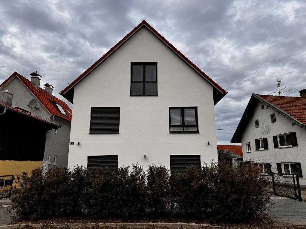 una casa blanca con ventanas negras en un día nublado en Ferienziel Wibmer, en Landsberg am Lech