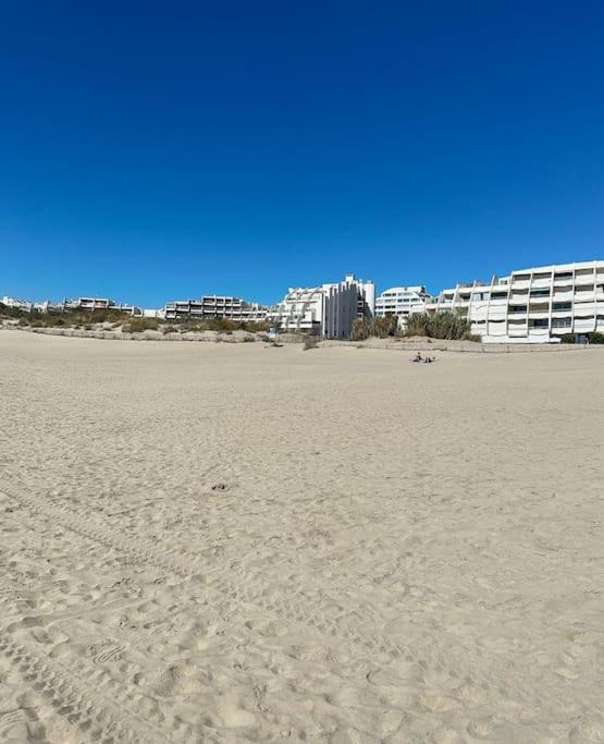 - une vue sur une plage avec des bâtiments en arrière-plan dans l'établissement Appartement en bord de mer, à La Grande Motte