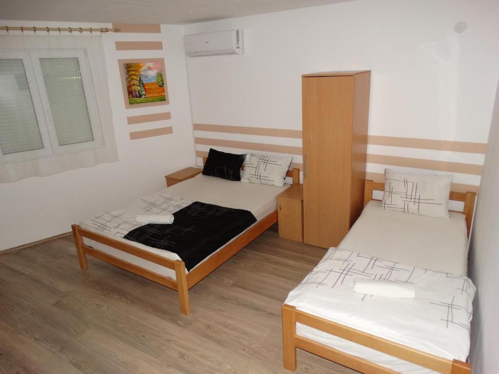 a small room with two beds and a window at Vila Jenic in Soko Banja