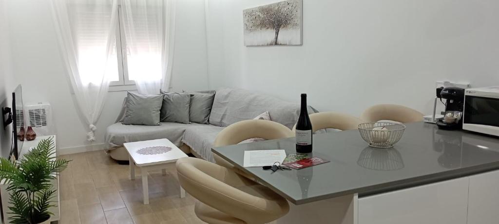uma sala de estar com uma mesa e um sofá em Dúplex Casa Ana Apartaclub La Barrosa em Chiclana de la Frontera