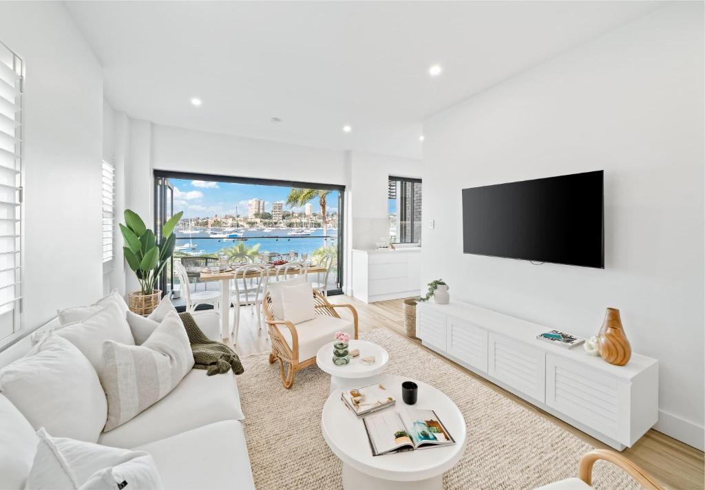 Il comprend un salon doté d'un mobilier blanc et d'une télévision à écran plat. dans l'établissement Peach at Palm View Collective, à Sydney