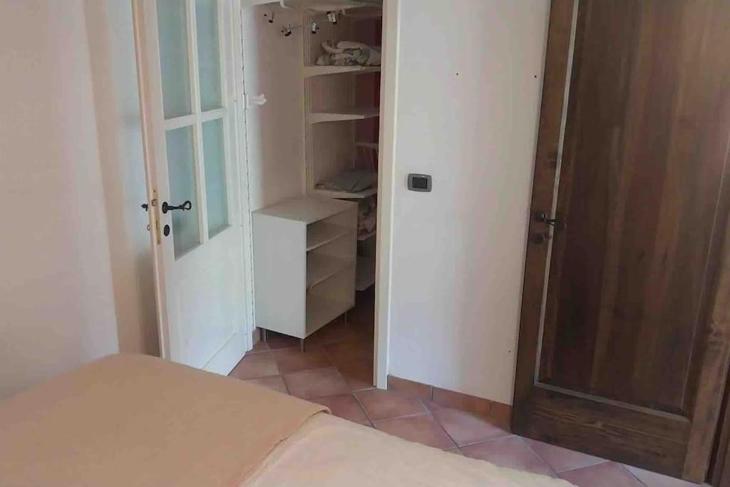 een slaapkamer met een bed en een open deur bij Il Conte, Alloggio romantico per Coppie + Piscina in Serravalle Pistoiese