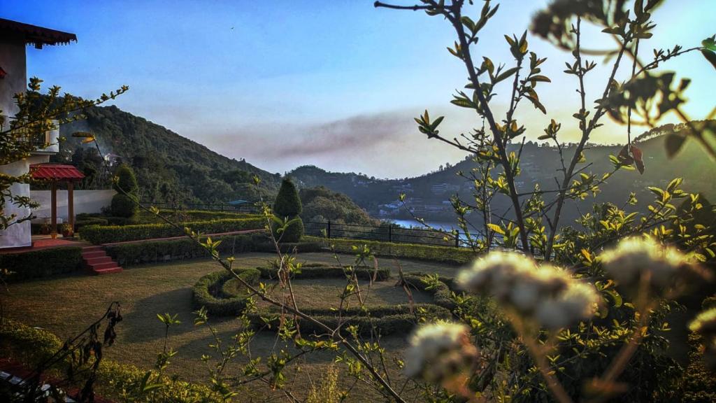 a garden with a view of a mountain at Sundew-n-Lake in Nainital