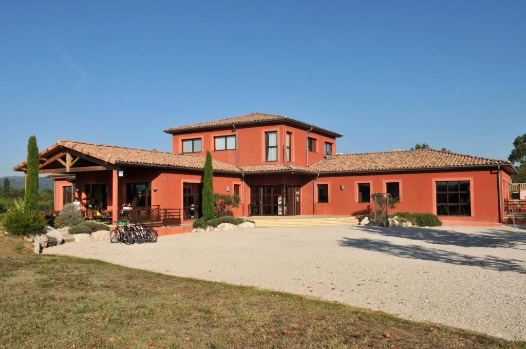 una casa grande de color naranja con una entrada grande en Domaine d'Agrippa, en Châteauneuf-sur-Isère