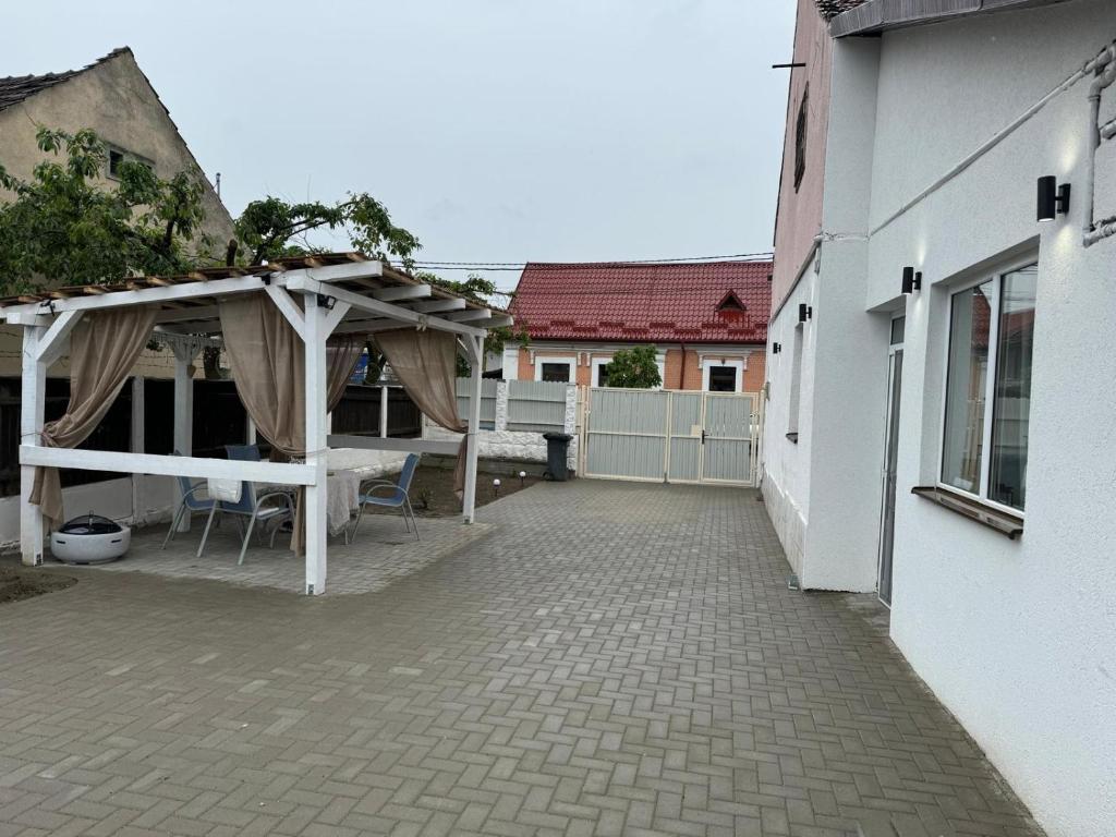 a patio with awning and tables and chairs next to a building at Casa Elena, Ocna Mureș in Ocna-Mureşului