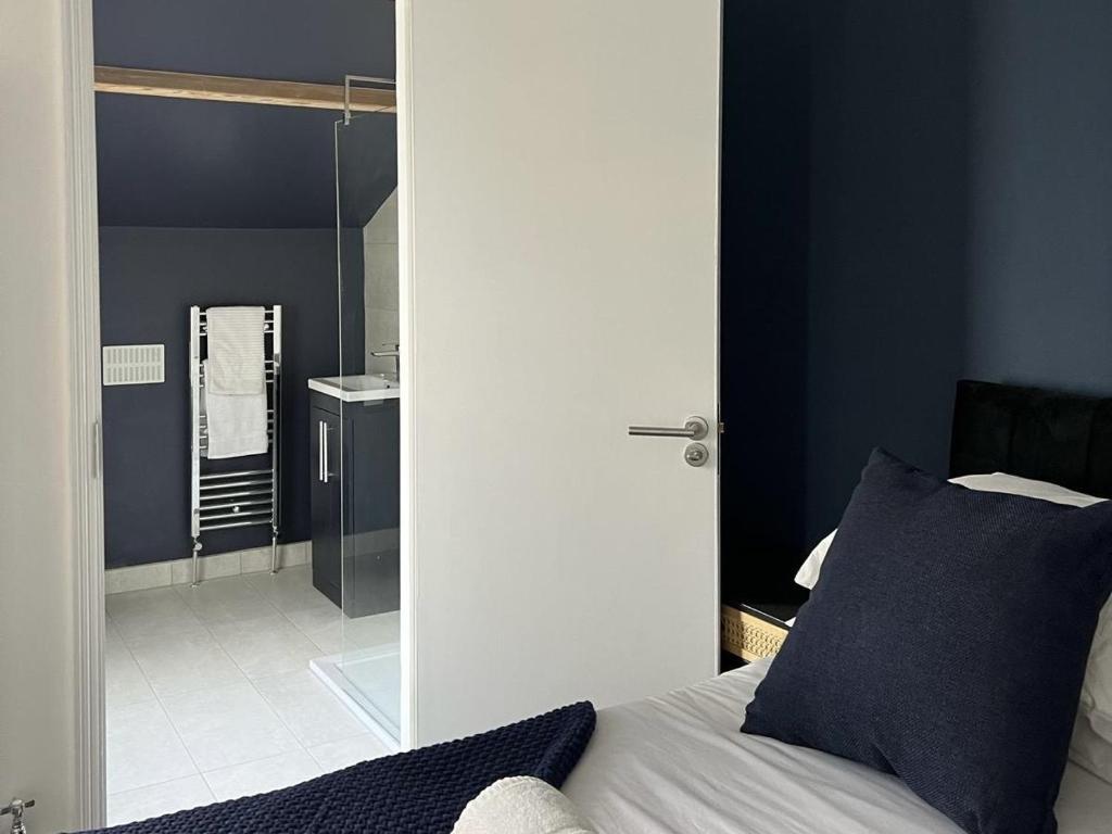 a bedroom with a bed and a bathroom with a shower at House Next to the Station in Watford